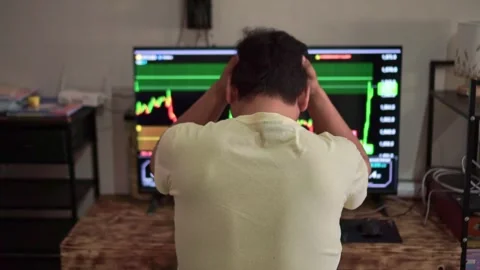 Ear view of a stressed man holding his head while watching stock market charts Stock Footage 348340126