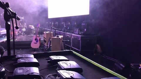 In-Ear wireless system packs on a stage before concert with instruments in back Stock Footage 83254682