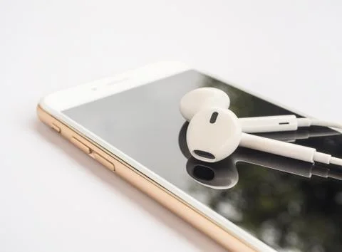 Earbuds on top of smartphone screen isolate Stock Photos