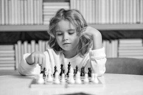 Premium Photo  Young white child playing a game of chess on large chess  board chess board on table in front of school boy thinking of next move