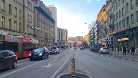 Early evening streetscape on Murtenstrasse in Bern, Switzerland. Cars pass a Stock Footage 340947448