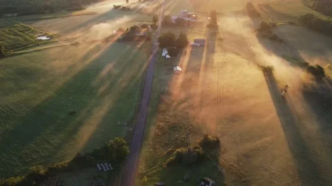 Early in the morning, drones fly over farmhouses, fields and pastures as the gol Stock Footage 170938861