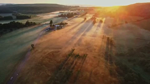 Early in the morning, drones fly over farmhouses, fields and pastures as the gol Stock Footage 170938893