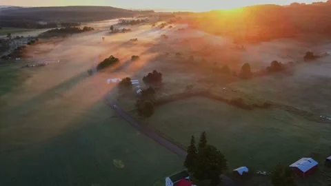 Early in the morning, drones fly over farmhouses, fields and pastures as the gol Stock Footage 170938908