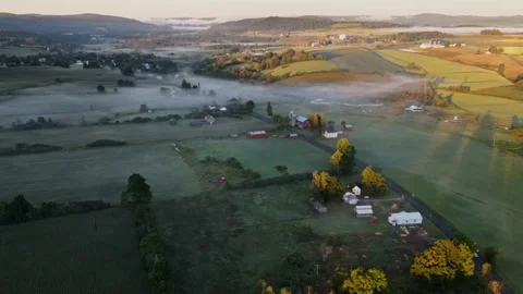 Early in the morning, drones fly over farmhouses, fields and pastures as the gol Stock Footage 170938928