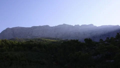 Early morning light over a rugged mountain ridge and dense pine forest Stock Footage 341558029