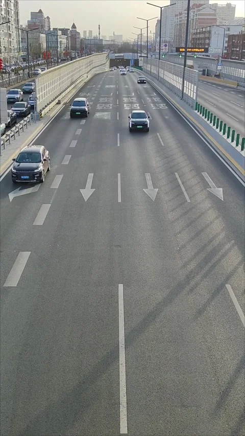 Early morning, looking down at the busy scene of cars exiting the tunnel. Video stock 301153134