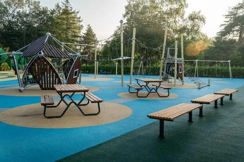 Early morning in a public park featuring playground equipment and benches Stock Photos