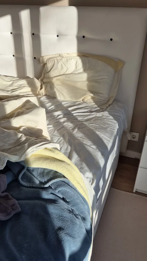Early morning sunlight casting long shadows across an unmade bed Stock Footage 331008572