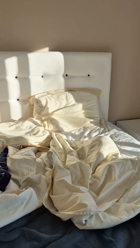 Early morning sunlight casting long shadows across an unmade bed Stock Footage 331008829