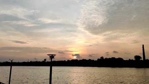 Early morning sunrise with river reflection and cloudy sky Stock Footage