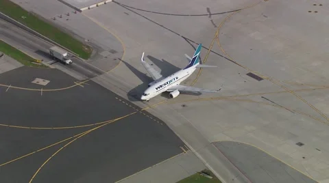 Early Morning WestJet Taxi Around A Corner Stock Footage 59883755