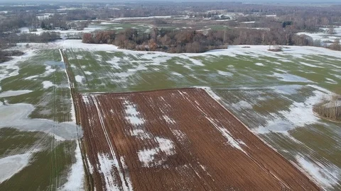 Early spring farm fields panorama with frozen water puddles, aerial Stock Footage 103468537