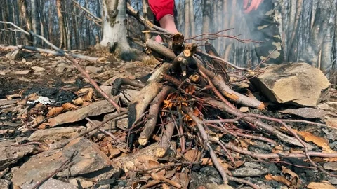 Early spring forest. A man makes a fire on the top of the mount. Stockbeeldmateriaal 151649543