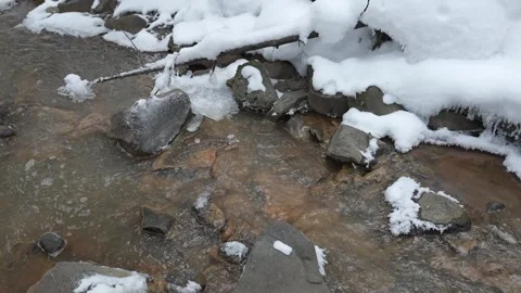 An early spring mountain or forest creek. The water turns slightly cloudy from Video stock 329099003