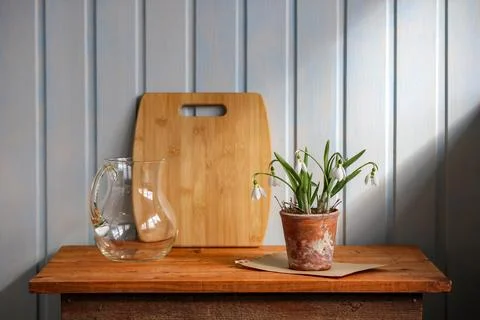 Early spring snowdrops in rustic clay pot on wooden table, natural light bo.. Foto stock