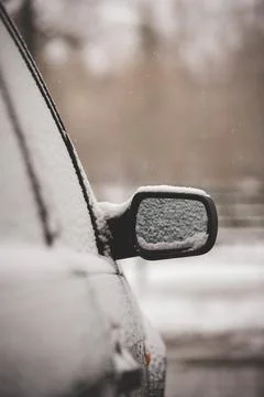 Early winter. Unexpected snow covered cars and roads. Door mirror Stock Photos