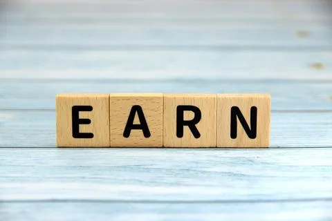 "EARN" text or message short word english letter on wooden cubes block with.. Stock Photos