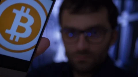 Earned on the stock exchange BTC. Man earns bitcoins on his bitcoin farm. Male Stock Footage 82367264