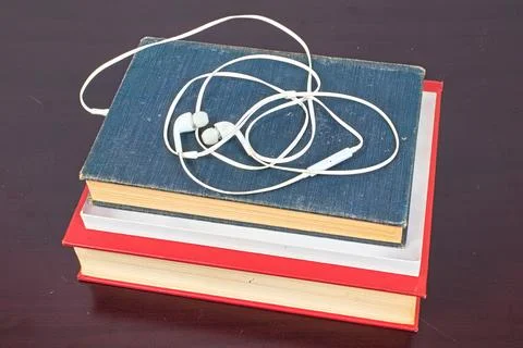 Earphones Plugged into a Stack of Books Stock Photos