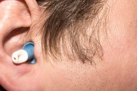 Earplugs inserted into the ears of man Stock Photos