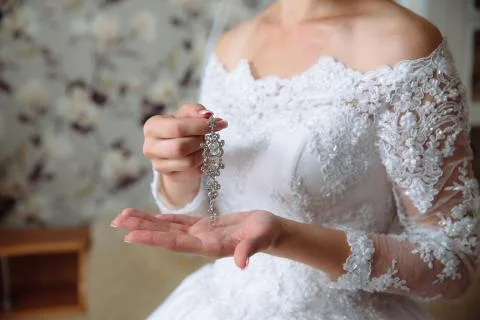 Earrind in the hands of the bride Stock Photos