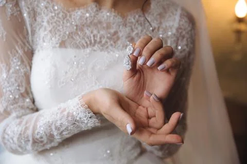 Earrind in the hands of the bride Stock Photos