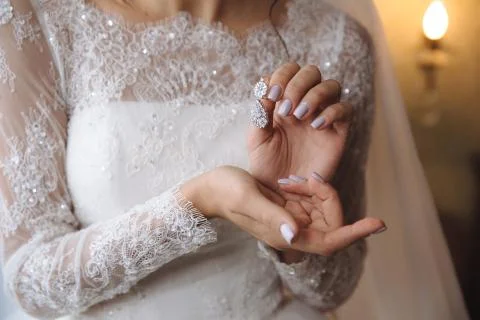 Earrind in the hands of the bride Stock Photos
