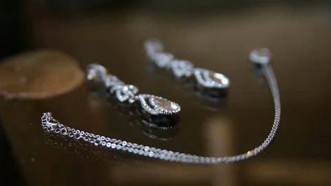 Earring and a chain with a pendant shimmer in the sunlight Stock Footage