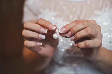 Earring in hands 2494. Stock Photos