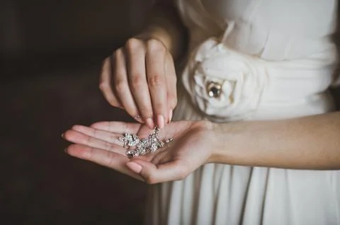 Earrings in hands of the bride 2085. Stock Photos