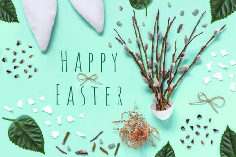 Ears of a hare, branches with kidneys, eggshells, green leaves, on a light ba Stockfoto's