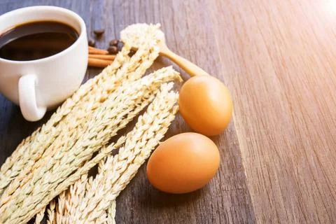 Ears of wheat and coffee with egg on a dark wooden table background. Foto stock