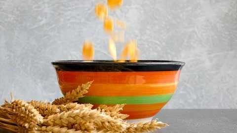 Ears of wheat and cornflakes falling into bowl,slow motion Video stock 97710615