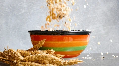 Ears of wheat and muesli falling into bowl,slow motion Stock Footage 97710490