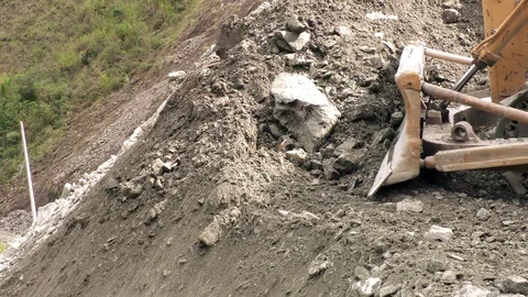 Earth mover pushing rocks to the river in the breathtaking Ecuadorian Stock Footage 128450967