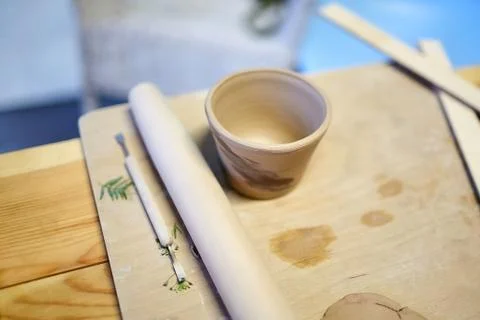 Earthenware. Ceramic products from raw clay. Mug, stack, rolling pin Stock Photos