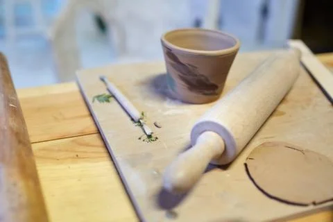 Earthenware. Ceramic products from raw clay. Mug, stack, rolling pin Stock Photos