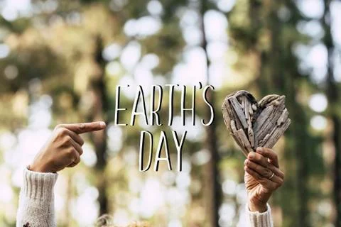 Earth's day text message with human people hands taking a wood hearth and gre Foto stock