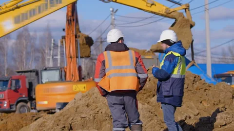 Earthwork at a construction site,  excavators digs a place for a foundation Stock Footage 147630519