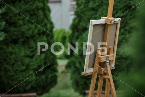 Easel with canvas in garden. Stock Photos