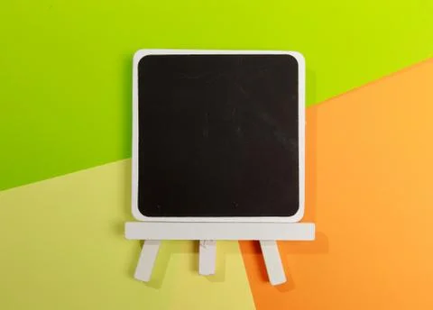 Easel with frames empty for drawing on colored background. Stock Photos