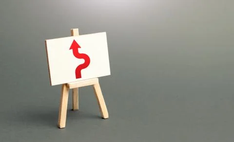 An easel with a red arrow avoiding an obstacle. Purposefulness and perseveran 写真素材