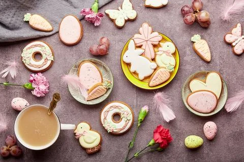 Easter aesthetic coffee time flat lay. Decorated glazed cookies, coffee cup Stock Photos