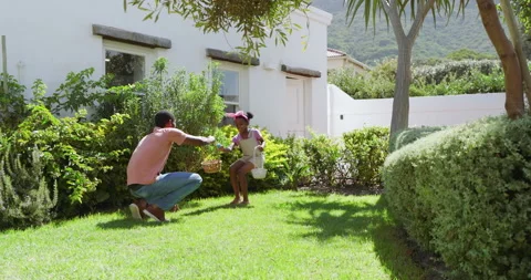 Easter, african american father hugging daughter in sunny garden, enjoying Stock Footage 310487596