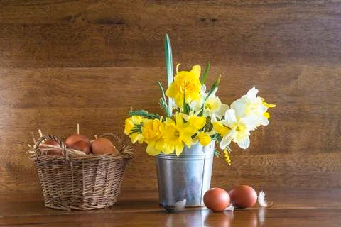 Easter and spring holiday composition. Bunch of daffodils in bucket and old w Stock Photos