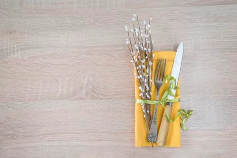 Easter and spring table setting. Antique fork and knife, yellow linen napkin  Stock Photos