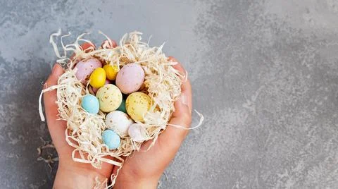 Easter background with blue Easter eggs in nest of spring flowers. Top view w 库存照片