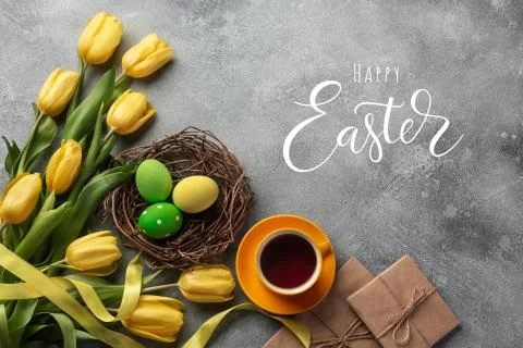 Easter background with blue, green eggs and a cup of tea in nest and yellow t Stock Photos