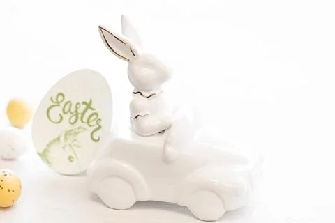 Easter background with a ceramic hare in the car and eggs on a white background, Stock Photos